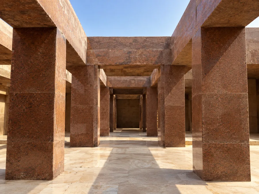 أعمدة وعتبات ضخمة من الجرانيت الأحمر داخل معبد الوادي لخفرع، وضوء الشمس يسقط على الأرضية الفاتحة